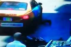 突然開いた車のドアに激突し道路に倒れたところをタクシーに轢かれるバイカー