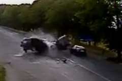 車同士が激しく正面衝突し壊れたパーツが道路脇に立っていた女性を襲う