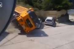 坂道をバックしてきたトラックが横転し駐車車両を押し潰す