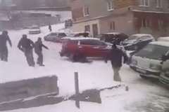 雪の道路で滑ってきた車に押され駐車車両との間に挟まれる歩行者