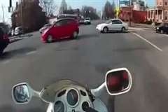 車列の間を走り抜けようとしたバイクが車に衝突する