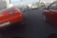 渋滞の車列をすり抜けていたバイクが突然バックした車に衝突!